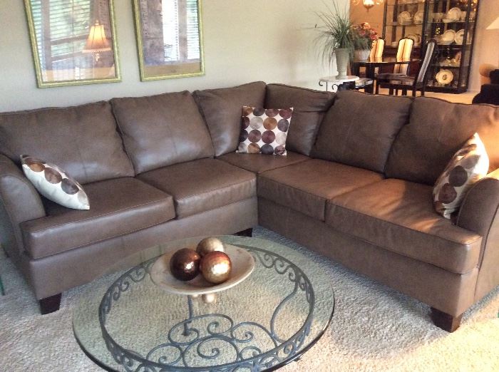 Rich cocoa leather sectional and glass and wrought iron coffee table