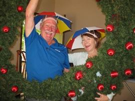 Walt and Jackie sporting umbrella hats and an extra large Christmas wreath.  Come join the fun!