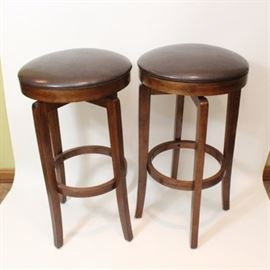 Pair of Barstools by Hillsdale Furniture: A pair of Hillsdale Furniture Barstools. These identical barstools features dark brown wooden block legs with a round stretcher and a round leather seat.