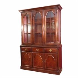 China Cabinet by Broyhill: A Broyhill china cabinet. This cabinet feature three glass doors opened via brass key. There are three glass shelves within and a display light above. The bottom features three drawers and three cabinets for additional storage. Marked “Broyhill Quality Furniture”.