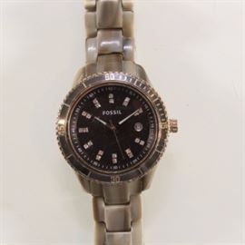 Silver Framed Fossil Watch: A round silver framed Fossil analog watch with a silver link.