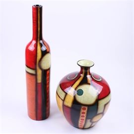 Pair of Colorful Contemporary Vessels: A pair of colorful, contemporary vessels. The vases are made of a metal or composite material, with a high gloss finish. The pair are decorated with abstract shapes, in bright colors, including red, orange, cream, teal blue and golden yellow. They are marked “Made in China”.