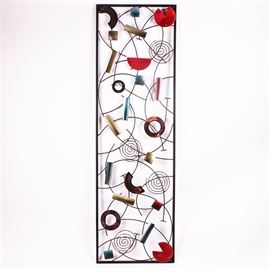 Whimsical Metal Wall Art Sculpture: A whimsical contemporary wall art sculpture. The 4-foot long rectangular metal sculpture has a dark metal frame, with overlapping curved metal wires and geometric shapes, welded randomly together. The geometric shapes are differently colored, including red, peacock blue, gold, pink and copper. Metal hanging hardware is welded to the back, allowing this piece to be hung either horizontally or vertically. No maker’s marks.