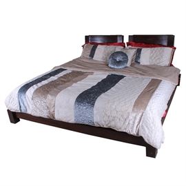 King Size Contemporary Bed Frame with Bedding: A king size contemporary bed frame with bedding. The bed is made of a dark stained wood, with straight, contemporary lines. The bed frame includes a headboard, and three side rails, plus wood slats that support a mattress (mattress not included). Included with the bed frame is a comforter, four pillow cases, a flat sheet, a fitted sheet and two accent pillows. No maker’s marks. This item matches item 17DEN021-002.