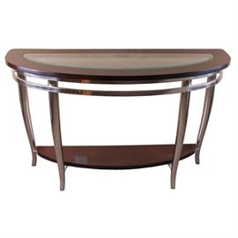 Contemporary Metal and Wood Console Table: A contemporary demilune console table. The table features a wood top with a beveled glass insert, which rests on polished chromed metal legs. There is an open wood shelf near the bottom, supported near the floor. No maker’s marks. Please note, this item is located on an upper floor.