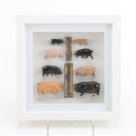 1950s Metal Pig Display "Dining Al Fresco": A 1950s metal pig display Dining Al Fresco assembled by artist Joel Waldman. This display features eight 1950’s lead toy pigs dining at troughs. This display is presented behind glass in a white wood frame.
