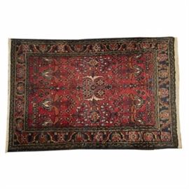 Hand Woven Wool Persian Accent Rug: A hand woven wool Persian accent rug. The rug has a central palm medallion on a dense floral field in a palette of blue, tan, rose, and brown on a burgundy background. The rug’s wide outer border has a coordinating design on a navy field.