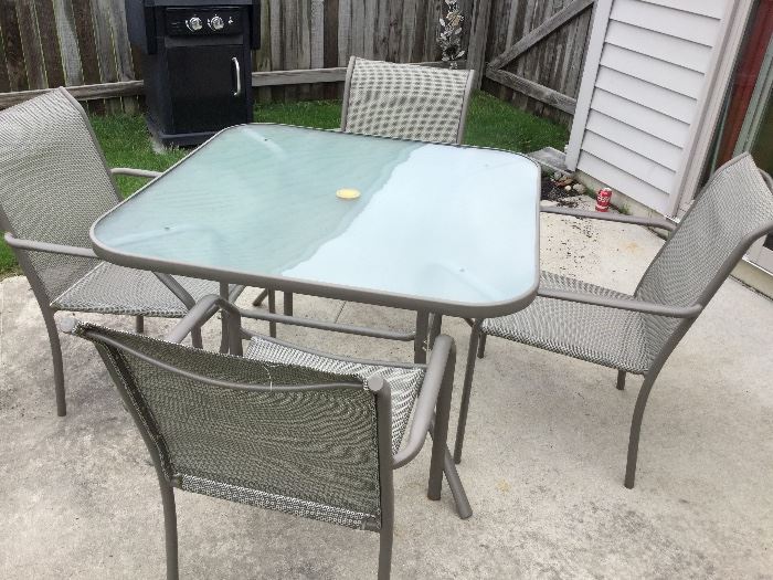 glass top powder coated patio table and four chairs