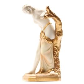 Antique Royal Worcester Figurine "The Guardian Surprised": An antique Royal Worcester figurine titled The Guardian Surprised c 1917. The partially gilded figurine was modeled by Sir Thomas Brock and features a partially draped female figure leaning on a tree. Maker’s mark to the underside. Number 486.