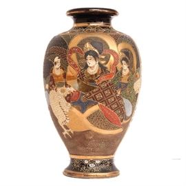 Antique Japanese Satsuma Kinkozan Vase: A Japanese Satsuma ware vase produced by the Kinkōzan pottery. This distinctive vase features a serene domestic scene with ladies in elaborate dress, a child and a dragon. The opposite side of the vase depicts a fighting scene between a dragon tail and a youth against a blue-black ground with applied scale embellishments. The vase has golden accents and hand-applied embellishments throughout. It is marked to the underside “Kinkōzan, Made by Asanō” (金光山淺野造) underneath a Shimazu mon. It likely dates from the late 19th century or early 20th century.