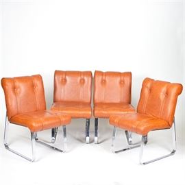 Mid Century Modern Vinyl and Chrome Chairs by Douglas Furniture: A set of Mid Century Modern vinyl and chrome chairs by Douglas Furniture. This collection includes four chairs with an orange vinyl upholstered back and seat cushion with a rolled top and bottom. These chairs have no arm rails and two front to back chrome legs. They are labeled “Douglas Furniture Corp., Chicago, Ill” on a tag to the underside.