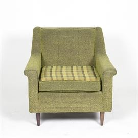Vintage Upholstered Armchair: A vintage upholstered armchair. This chair features a straight crest rail with cushion back and sloping sides falling to curved armrests with a removable plaid seat cushion rising on tapered wooden legs. There are no visible maker’s marks or labels on this piece.