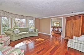 Living room in sage and green palette. Storage armoire or entertainment center.