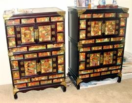 Slightly unmatched storage cabinets decorated with scenes fro everyday life. 