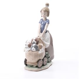 Lladro "Litter of Fun" Figurine #5364: A Lladro figurine titled Litter of Fun. This porcelain piece depicts a little girl wheeling a cart of puppies in a baby carriage. There is an underglaze blue printed mark reading “Lladro Hand Made in Spain #5364 B-23 E”.