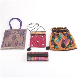 Colorful Handmade Pouches and Handbags: A group of Indian pouches and handbags. The pieces are made from colorful textiles with brocade borders and attached embellishments including beading mirrors. A brocade handbag has a two elephant design and a wallet style piece brocade stripes.
