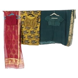 Sarees and Cholis: A collection of sarees and cholis. This selection includes six items, featuring a maroon saree with gilt accents, a maroon choli, a teal choli, and a teal saree with a gilded, paisley motif. Also included is a chartreuse choli with a saree that showcases a foliate pattern. The teal saree is marked by the manufacturer.