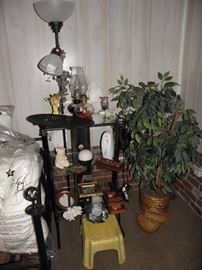 Floor lamp, glass shelf unit, oil lamps, faux plant, duvets, paint stool, small mirrors
