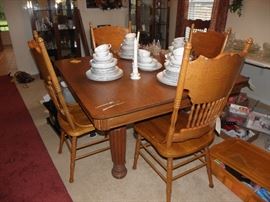 Four press back chairs, five leg Oak table with two leaves.