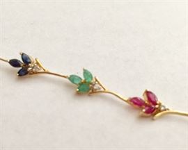 Sapphires, emeralds, rubies and diamonds in 12K gold setting 