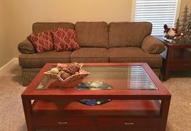 Glass-top coffee table and matching end table are offered, as is the sofa shown