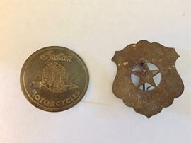 Vintage brass Indian Motorcycles badge, left, and antique brass Sante Fe train conductor's badge