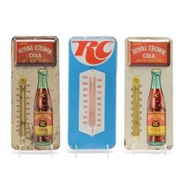 Vintage Royal Crown Cola Thermometer Signs: A pair of vintage Royal Crown Cola metal advertising thermometer signs including a blue sign with 1970s RC logo, and an embossed metal sign with original Royal Crown Cola logo design, used until the 1930s. Both signs have an attached glass thermometer.