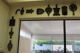 Large collection of iron trivets.