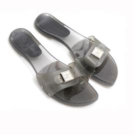 Chanel Slides: A pair of Chanel slides in size 39B. This style features a translucent smokey adjustable upper with logo branded gold tone hardware and a transparent sole marked with the Chanel name and logo to the footbed. The original box is included.