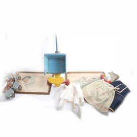 Collection of Vintage Prints and Play Room Items: A collection of vintage toys and more. Two Bessie Pease Guttman baby awake and baby asleep in gold tone wood frames, a wooden toy doll stroller in primary original colors, a vintage iron and ironing board and child’s aprons complete this selection of vintage playroom items.