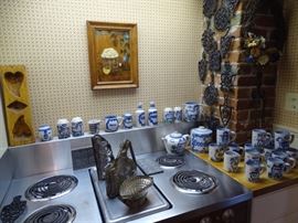 Mary Hadley mugs and misc. pieces. Trivet collection on wall.