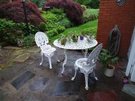Cast iron white round table with two chairs.