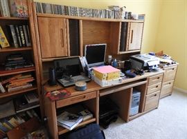 Large desk, computer equipment, CDs, office supplies