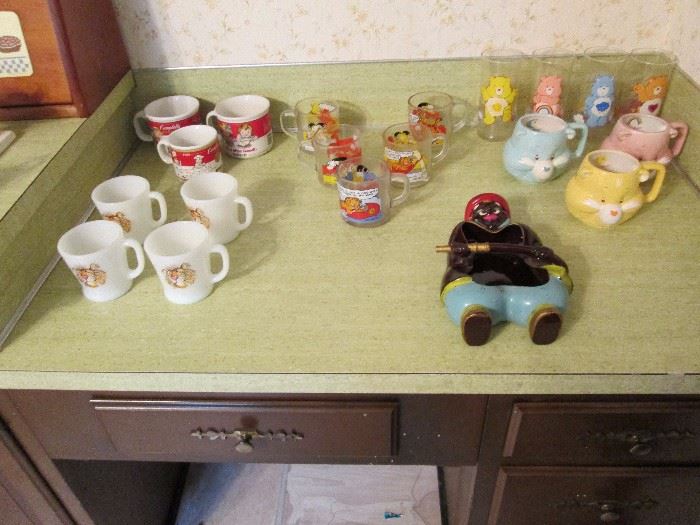 Collectible sets.  Fire King Esso set, Campbell Soup mugs, Garfield mugs, Care Bears mugs and glasses.  Vintage Fireman Ashtray