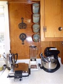 Vintage kitchen appliances, Griswold cast iron trivets on wall