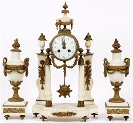 Lot#13, F. PELISSIER, PARIS FRANCE, MARBLE AND BRONZE GARNITURE SET, 3 PCS, H 17", W 12"Having white marble with gilt bronze adornments and leaf form finials. Clock has a hinged bezel opening to a white enamel face with Arabic numerals, two key wind. Sunburst pendulum is suspended between marble columns below the clock case. Resting on adjustable feet. A pair of matching urns. Marked "New York" on face at 6:00 and "F. Pelissier France" inside of case.