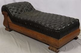 Lot#78, CARVED OAK AND LEATHER CHAISE LOUNGE, EARLY 20TH C., H 27", L 75"Having a carved oak frame and tufted leather cushion, wide bracket feet.