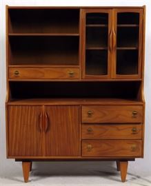 Lot#1185, MID-CENTURY MODERN CHINA CABINET, H 67", W 52", D 17"The lower section features three half drawers and two doors which open to reveal a single shelf on one side.  The upper section has two glass doors which open to tow shelves a three-quarter drawer and a compartment with one shelf.