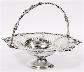 Lot#1289, VICTORIAN SILVER PLATE BRIDES BASKET, H 10" A silver plate brides basket, with a handle of acanthus leaf cartouches and masks of an elderly bearded man about the pierced basin.  Measures H.10", Dia.13".  Stamped '77' underneath the rim, no apparent marks otherwise. From the collection of Mrs. G. G. Scranton, international traveler from the late 1800's to the mid twentieth century. Friend and patron of Mrs. Dagny Carter, a notable scholar, influenced this collection.