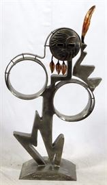 Lot#2124, GREG LEAVITT STAINLESS STEEL SCULPTURE, 1990, H 58" W 32" Greg Leavitt [American, 20th C.].  Depicting a figure with feathers.  Signed and dated.