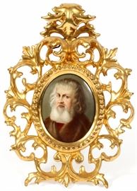Lot#2287, HAND PAINTED PORCELAIN PLAQUE, H 3.5", W 2.75", PORTRAIT OF A BEARDED SCHOLAR. Depicting a bearded man wearing a fur coat.  Mounted in a gilt wood easel frame.