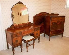 Antique / Vintage Bedroom Set: 3 piece set includes: vanity dresser with bench; headboard, foot board, and rails; 4 drawer chest of drawers.  Vanity: 50" W, 20" D, 66" H (inc. mirror). Bench: 25.5" W, 14" D, 18" H. Headboard 57" W, 49.5" H. Footboard 57" W, 30" H. Chest of drawers: 34" W, 19.5" D, 48" H. Bed and dresser on wooden casters, extra casters for vanity included. Built by John since 1891. Set is in good condition, commensurate with age.