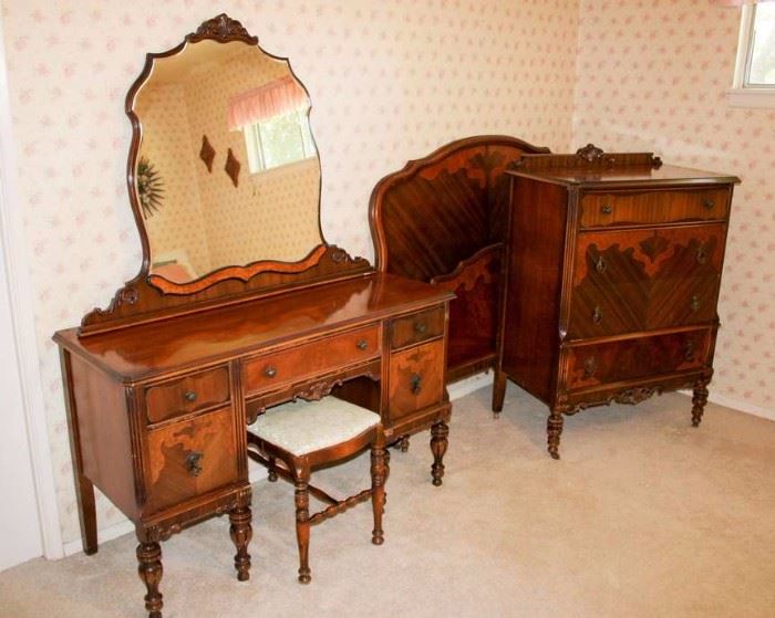 Antique / Vintage Bedroom Set: 3 piece set includes: vanity dresser with bench; headboard, foot board, and rails; 4 drawer chest of drawers.  Vanity: 50" W, 20" D, 66" H (inc. mirror). Bench: 25.5" W, 14" D, 18" H. Headboard 57" W, 49.5" H. Footboard 57" W, 30" H. Chest of drawers: 34" W, 19.5" D, 48" H. Bed and dresser on wooden casters, extra casters for vanity included. Built by John since 1891. Set is in good condition, commensurate with age.