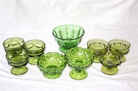 Nine Piece Vintage Green Pressed Glassware: one 4" x 6" emerald green dish, one 4.5" x 4.5" emerald green candle holder, one 4.5" x 4.5" emerald green candy dish, six olive green dessert dishes w/ two different designs
