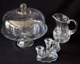 Three Piece Glassware: 6.5" L x 4.5" D x 6" H candlestick, 6" W x 7" H pitcher, 12" W x 11" H cake dish