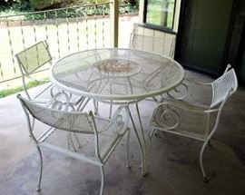 Wrought Iron Patio Table & Four Chairs: Chair backs swivel up and down. Just needs a fresh coat of paint.