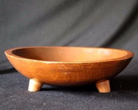 Vintage Munising Wood Bowl w/ Three Feet: The Munising Woodenware Factory operated from 1911 - 1955, in Munising, Michigan. The left leaning script of the maker's mark on the back of the bowl was introduced in the late 1930's - early 1940's. Bowl is oblong and measures 10" - 11" W x 3" H , and is in excellent condition commensurate with age.
