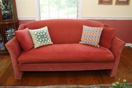Pair of Directional sofas in rose colored velvet.  Matching pillows included.  Needlepoint pillows not included