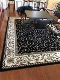 Large area rug and felt pad.  One of two sets of folding card tables and 4 chairs