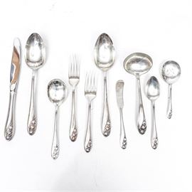 Gorham Lily of the Valley Sterling Silver Flatware: A collection of Gorham Lily of the Valley sterling silver flatware. This service for eight features the delicate blooms of the lily of the valley to the handles and includes eight dinner and salad forks, eight soup and tablespoons, eight butter knives with an additional patterned butter knife, and eight table knives. In addition, this collection includes a serving spoon, slotted spoon and one ladle.